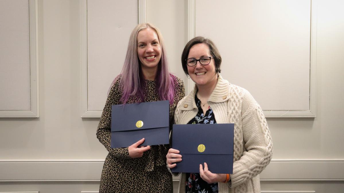 Two female recipients of the ABC program pose together with certificates