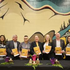 Group of Leaders from local First Nations, Metis community and district representatives, hold up their signed copies of the new enhancement agreement